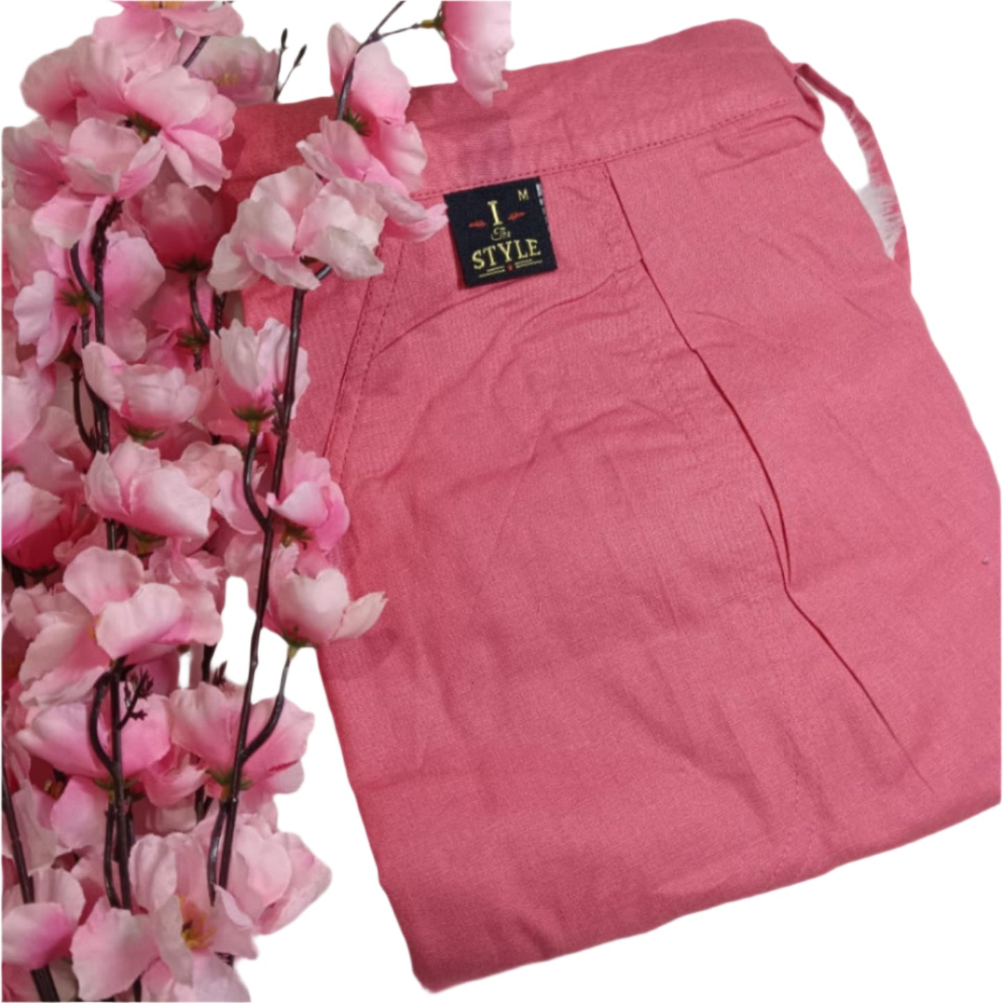 Pink pants with a label next to pink flowers on a white background