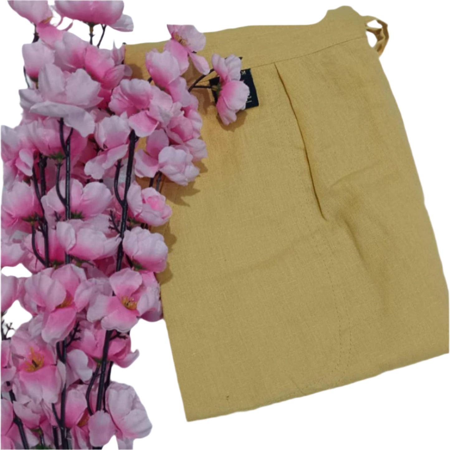 Mustard yellow skirt with pink artificial flowers on a white background