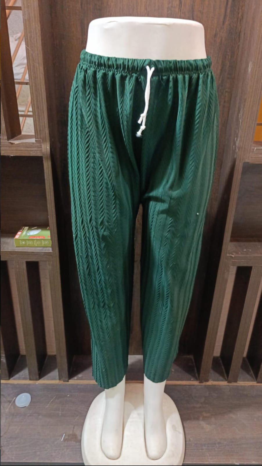 Green pants on a mannequin against a white background