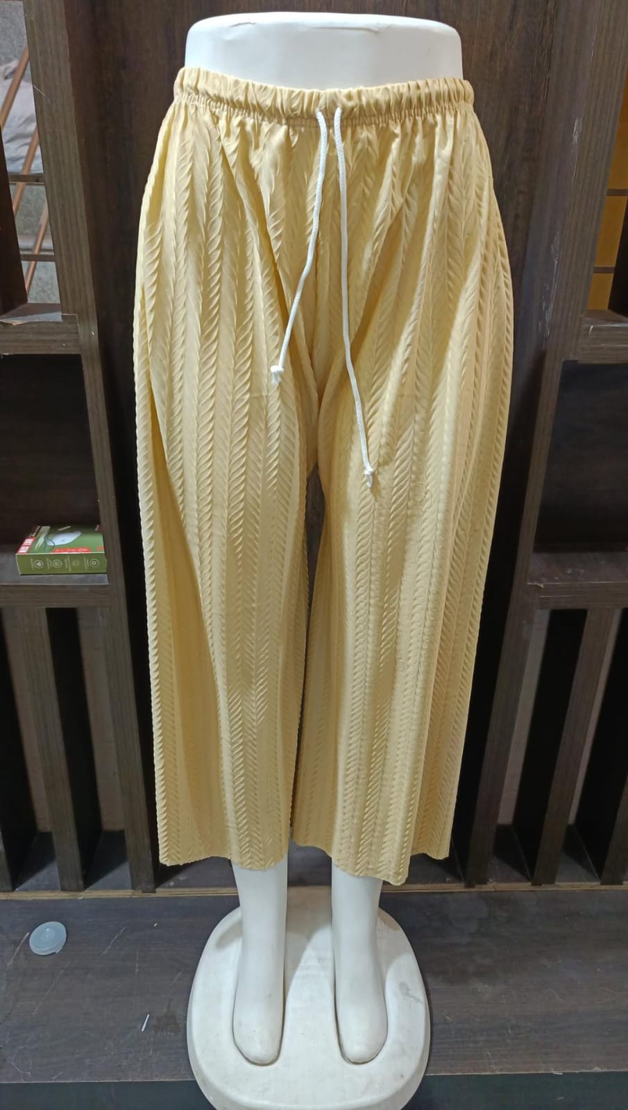 Beige pants on a mannequin against a white background