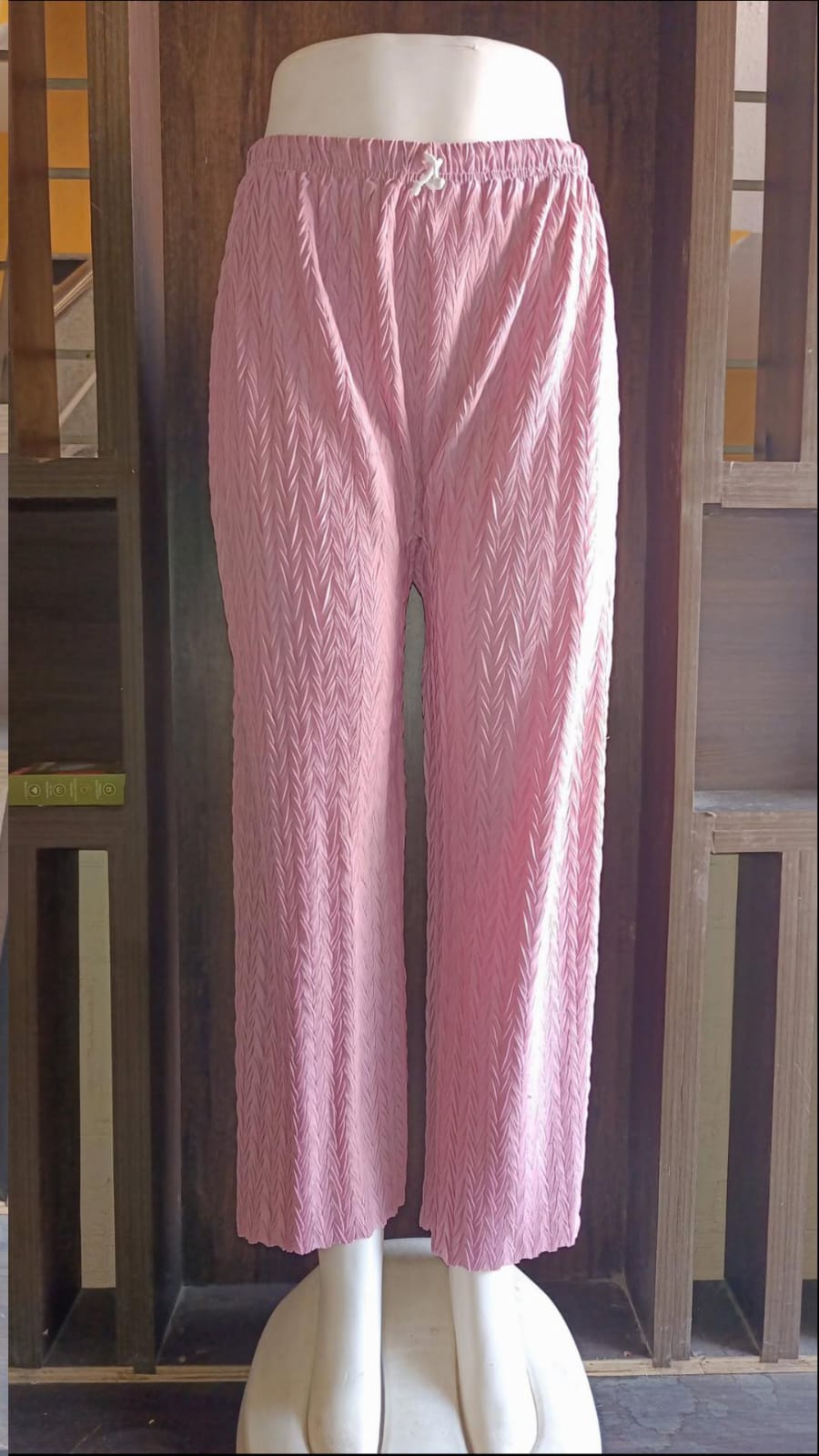 Pink textured pants on a mannequin against a white background