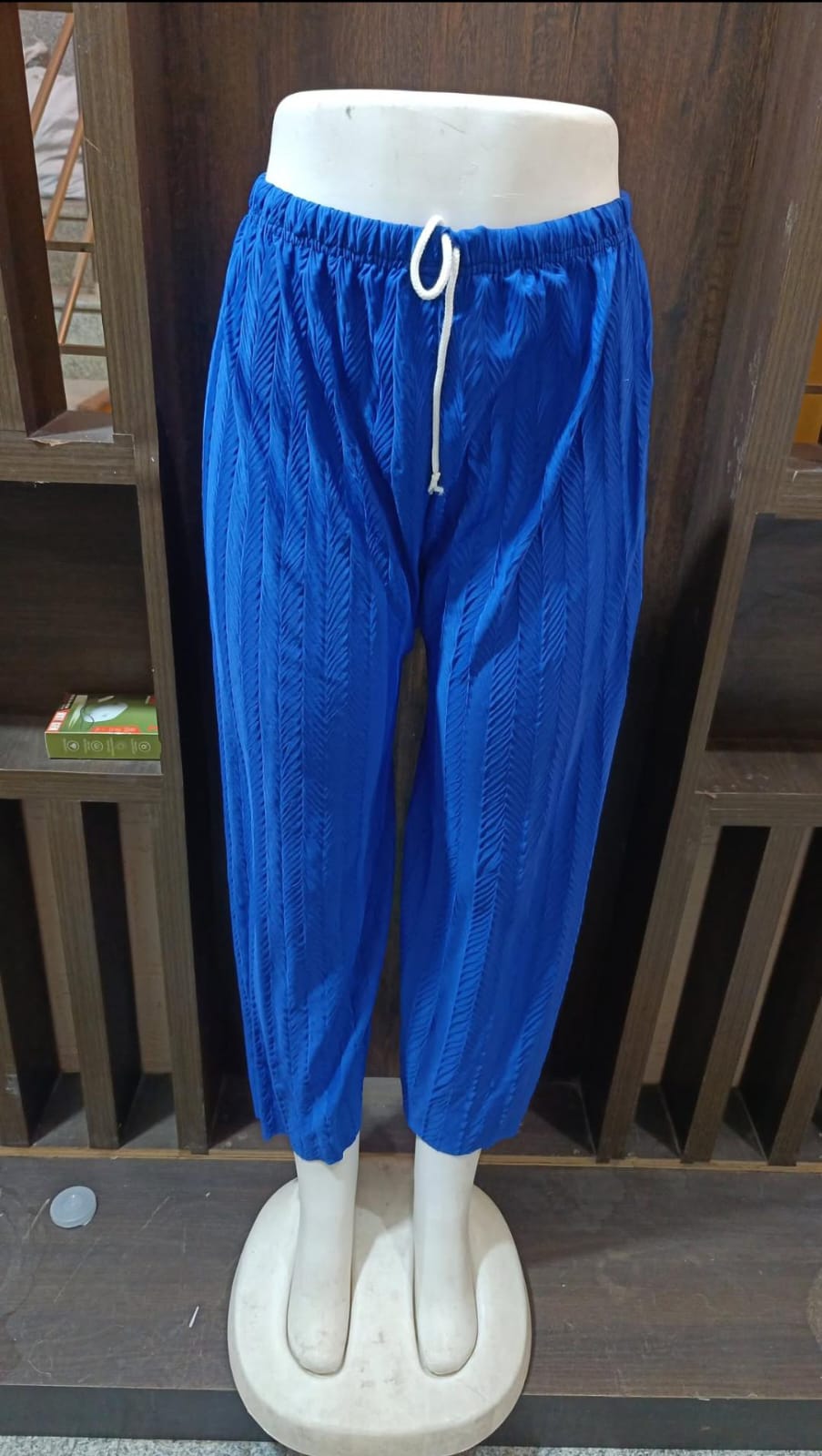 Blue pants on a mannequin against a wooden background
