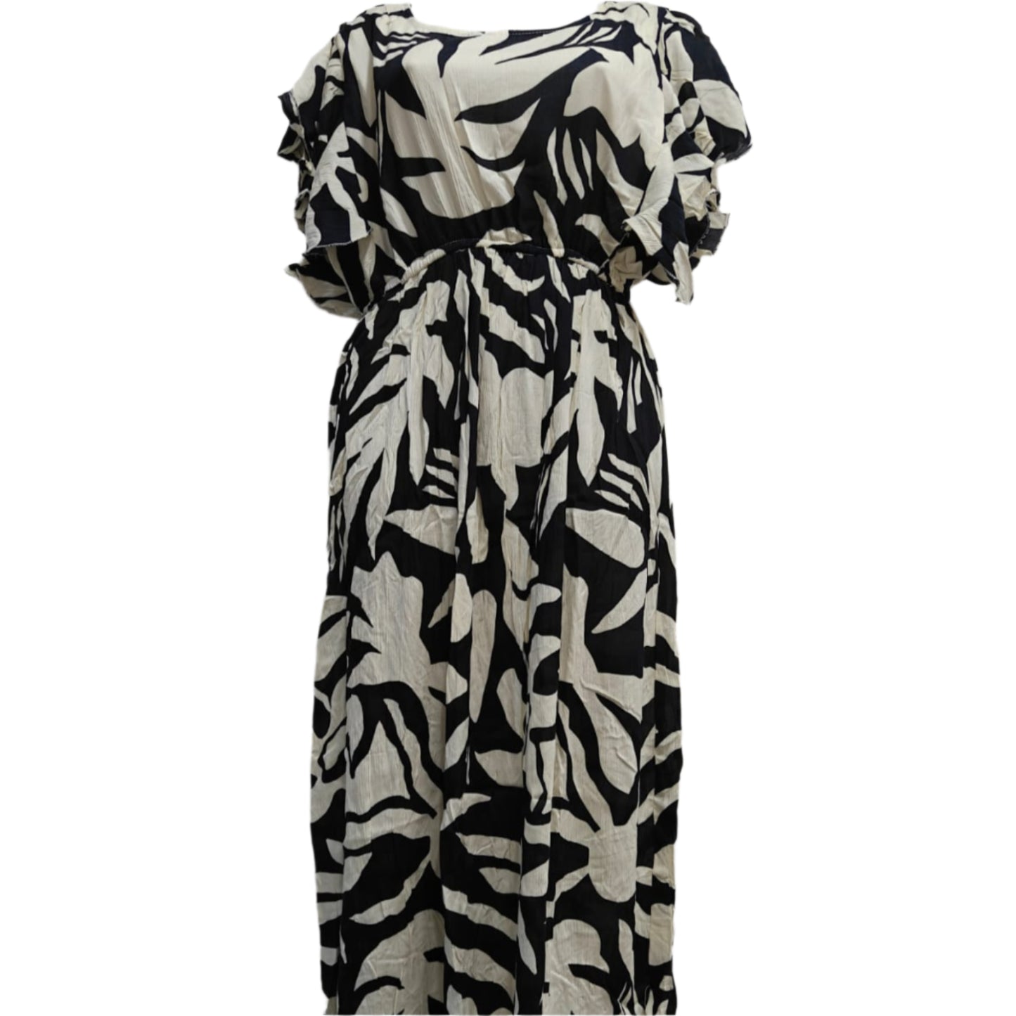 Black and white patterned dress on a mannequin against a marble wall.