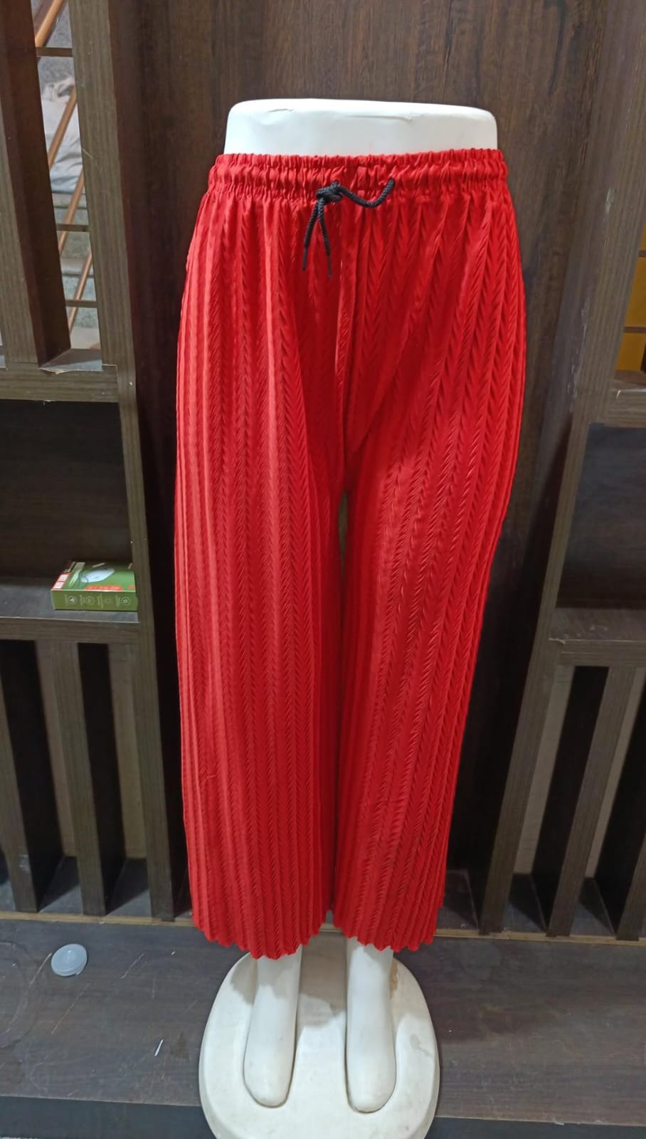 Red pants on a mannequin against a white background