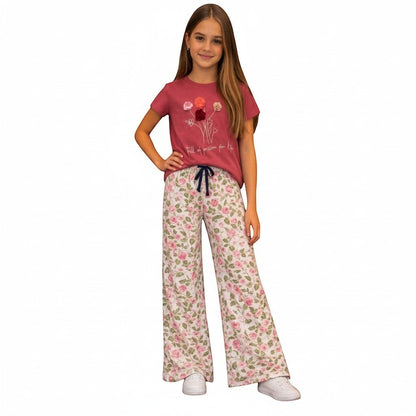 For She - Avalukaaga girl wearing pink floral wide leg pajama pants with drawstring waist and matching t-shirt.
